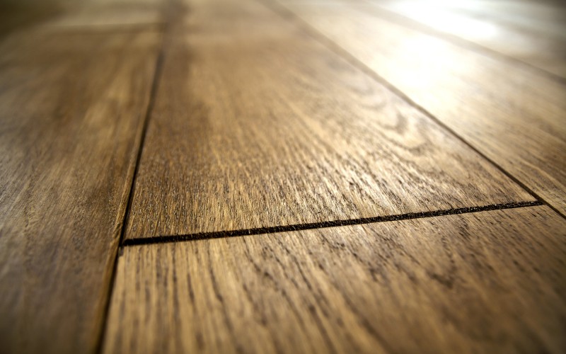 Detailaufnahme eines hochwertigen Holzbodens mit natürlicher Maserung und warmem Farbton